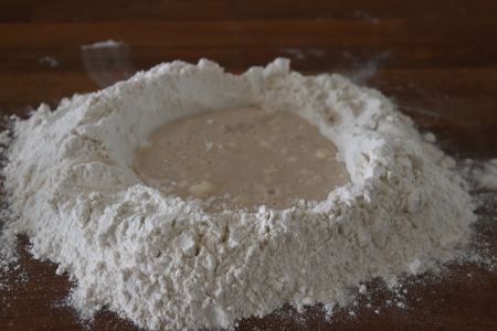 Making a well to bring together our vegan pesto bread dough